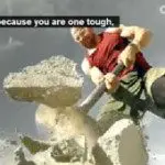 A person wearing a red and green outfit breaks large rocks with a sledgehammer under Seattle’s cloudy sky, embodying the grit of a true sports chiropractor. Subtitles read, "...because you are one tough. Sports Medicine Northwest - West Seattle Chiropractic Clinic