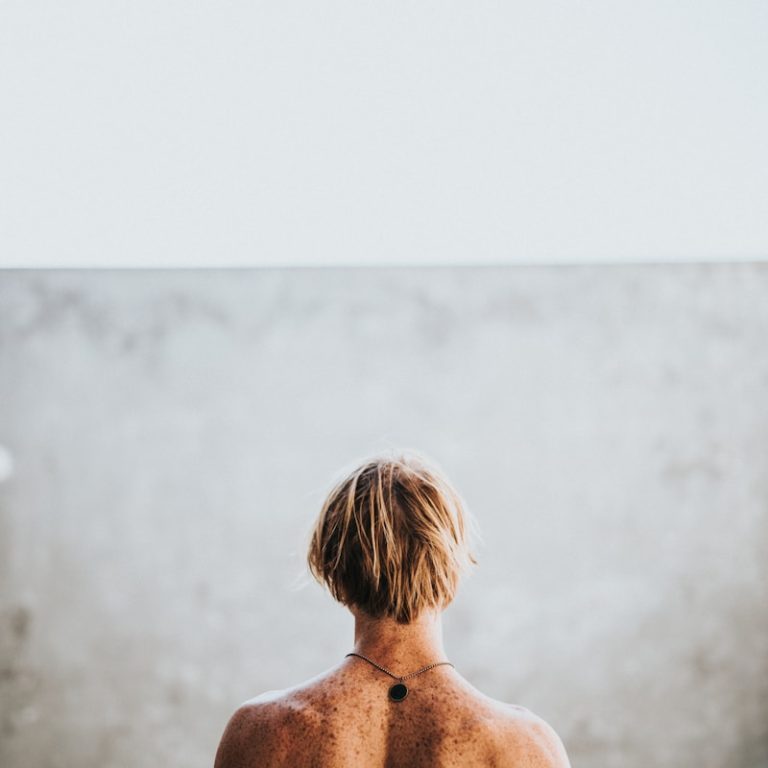 half naked man facing wall